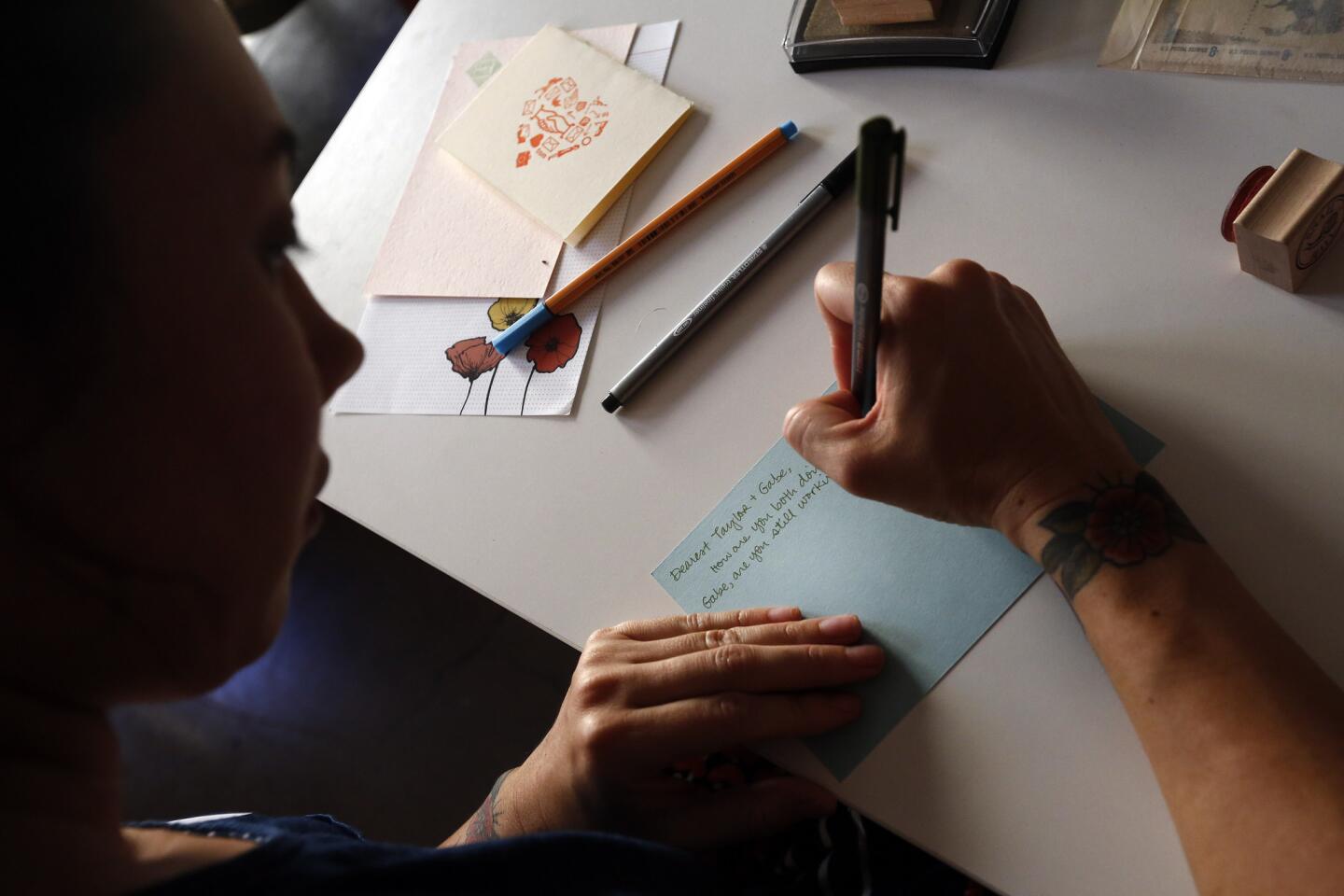 Erika Mulan writes a letter to a pen pal in Atlanta during the monthly gathering of the L.A. Pen Pal Club at Paper Pastries Atelier in downtown Los Angeles.