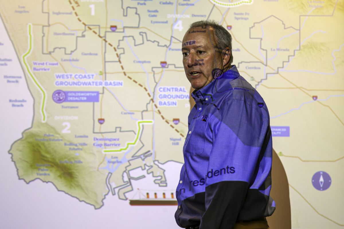 A man stands in front of a map of L.A.