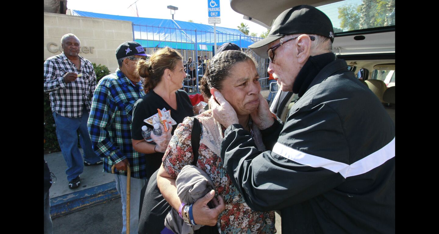 Dave Ross, also know as Water Man, comforts Jia Lawton, a homeless woman who gets emotional after receiving bottled water from Ross on 17th Street in San Diego.