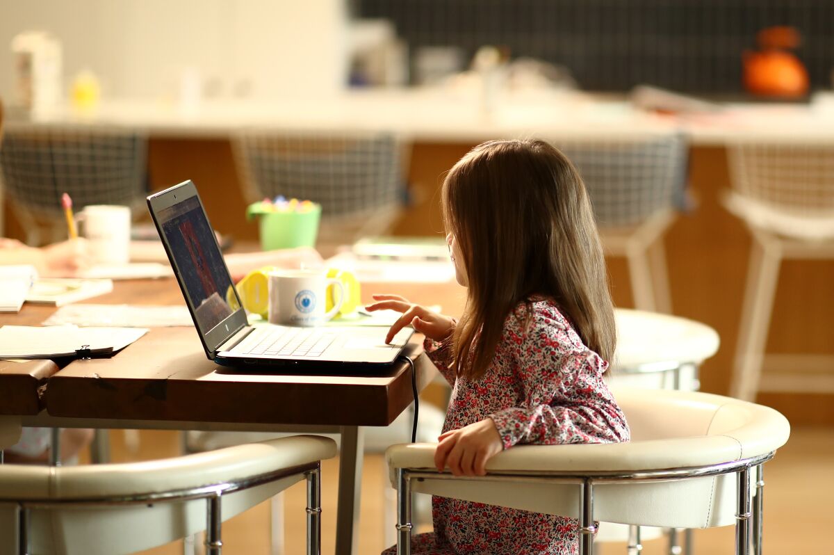 Kindergartener Meg Kramer does schoolwork at her home in San Anselmo