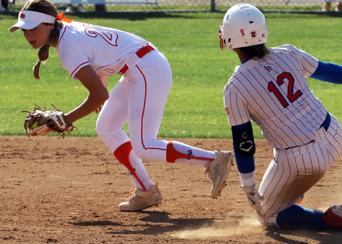 Huntington Beach's Macy Fuller (27) gets Los Alamitos' Allyssa Ramos (12) out at second in a Sunset League game Thursday.