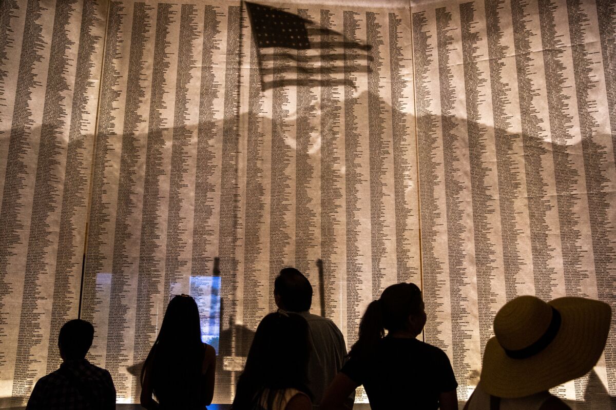 People look at a display of all the names of people, who were forced to relocate to Manzanar during World War 2.