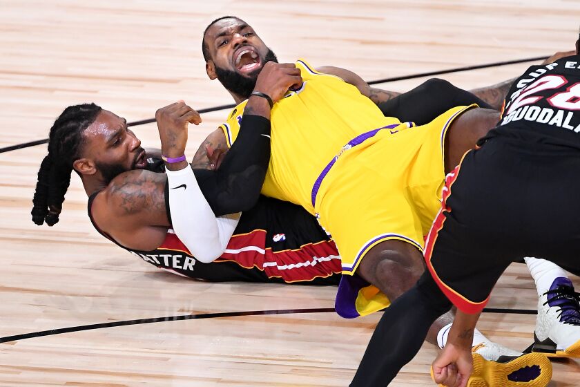 ORLANDO, FLORIDA SEPTEMBER 30, 2020-Lakers LeBron James and Heat's Jae Crowder get tangeled wile battling for a loose ball in the 2nd quarter in Game 1 of the NBA FInals in Orlando Wednesday. (Wally Skalij/Los Angeles Times)