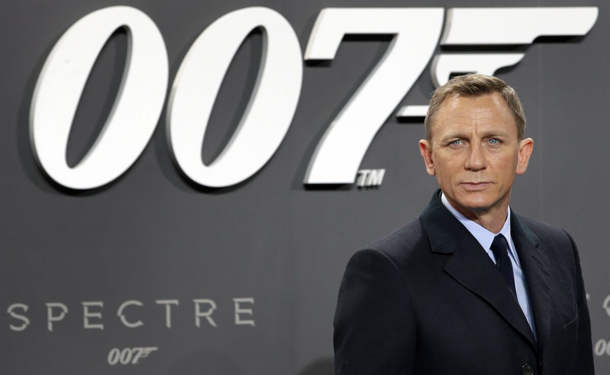 FILE - This is a Wednesday, Oct. 28, 2015 file photo of actor Daniel Craig poses for the media as he arrives for the German premiere of the James Bond movie "Spectre" in Berlin, Germany. The release of the James Bond film “No Time to Die” has been delayed again, this time to 2021, because of the effects of COVID-19 on the theatrical business. MGM, Universal and Bond producers, Michael G. Wilson and Barbara Broccoli, said on Twitter Friday that the 25th instalment in the franchise will now open globally on April 2, 2021. (AP Photo/Michael Sohn, File)