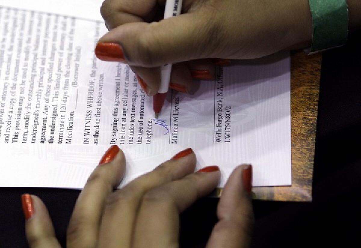 Wells Fargo customer Malinda Lievers of Edgewood, Md., signs paperwork for a mortgage modification in 2010.