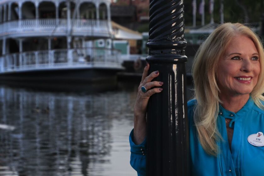 ANAHEIM ,CA., APRIL 25, 2019: Disneyland Art Director Kim Irvine is arguably the person most responsible for maintaining the look and feel of Disneyland. Irvine stands against a light post next to one of her projects, The Rivers Of America with the Mark Twain Riverboat in the background April 25, 2019. Kim Irvine's parents, Harvey and Leota Toombs were both Disney animators. Her mother's talking head is featured inside the crystal ball as Madame Leota in The Haunted Manson. Irvine's father in-law, Richard Irvine helped Walt Disney construct Disneyland (Mark Boster For the LA Times).