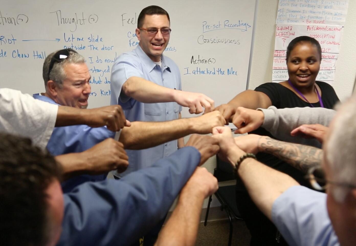 Daniel Hopper,center, leads his Offender Mentor Certification Program at Solano State Prison with a final cheer. Passage of Prop 57 is ushering in a massive overhaul of the prison parole system and with it programs like The Offender Mentor Certification Program at Solano State Prison in Vacaville.
