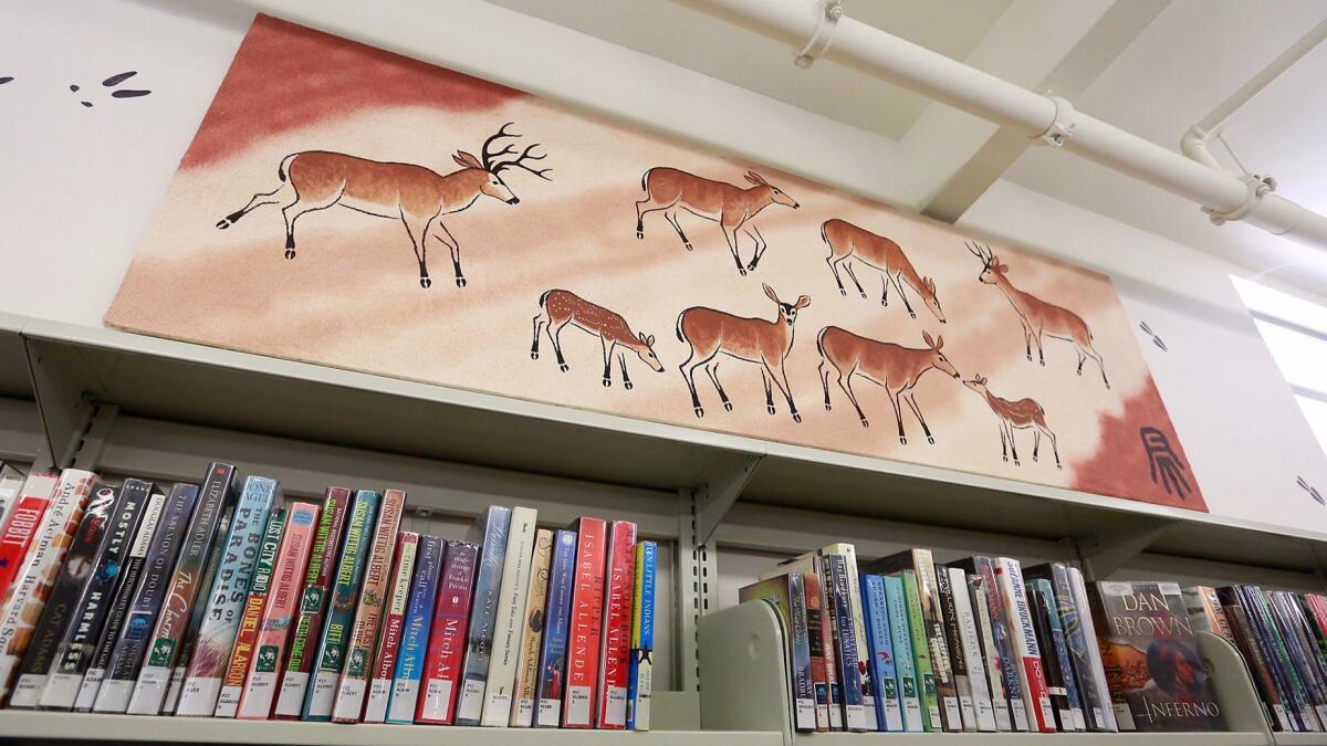 A herd is depicted by artist Robert Meyer along with their hoof tracks on a wall of the Library of the Canyons in Silverado Canyon.