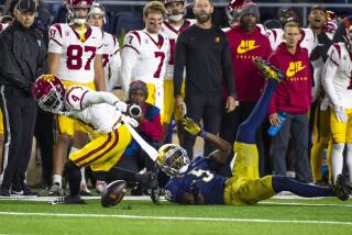 Notre Dame cornerback Cam Hart forces USC receiver Mario Williams (4) to fumble the ball 