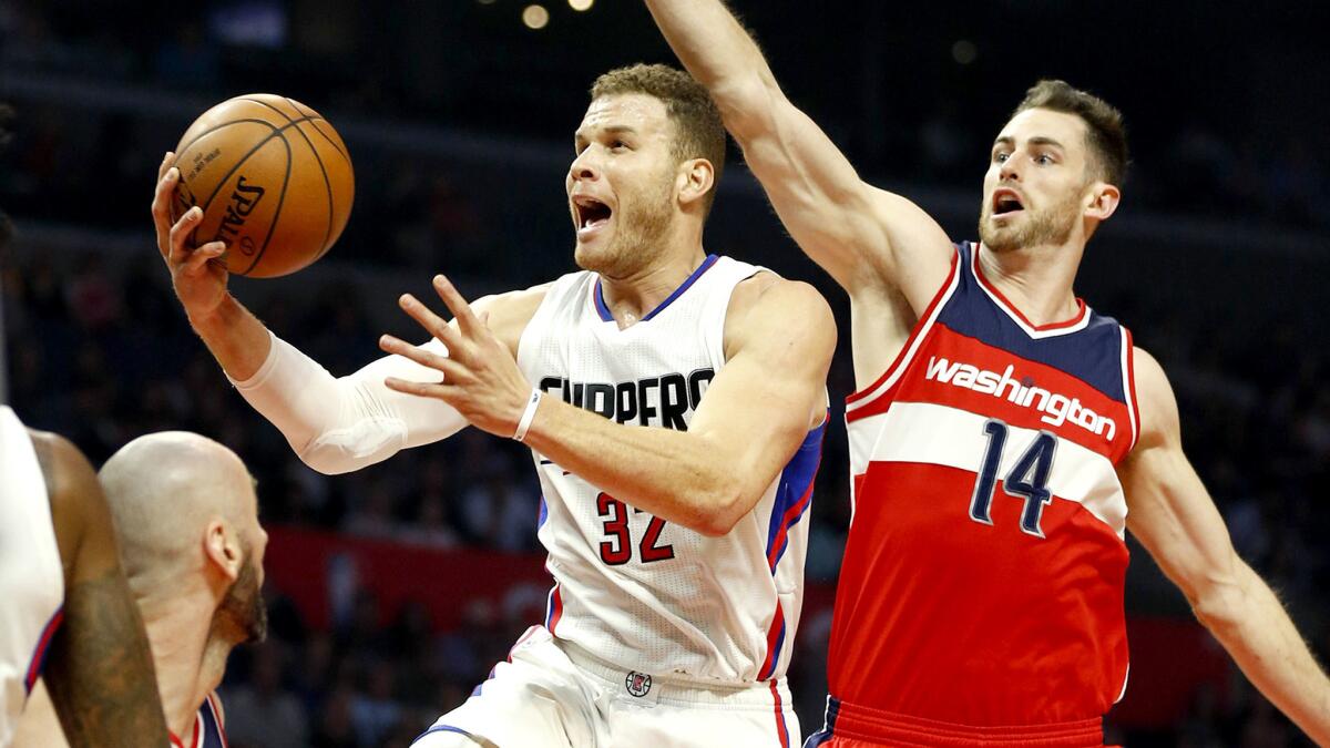 Clippers forward Blake Griffin elevates down the lane for a basket against Wizards forward Jason Smith (14) and center Marcin Gortat, left, during the second quarter Wednesday night at Staples Center.