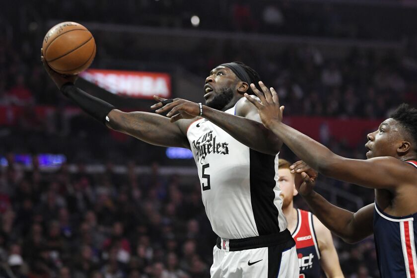 Los Angeles Clippers forward Montrezl Harrell, left, shoots as Washington Wizards center Thomas Bryant defends during the first half of an NBA basketball game, Sunday, Dec. 1, 2019, in Los Angeles. (AP Photo/Mark J. Terrill)