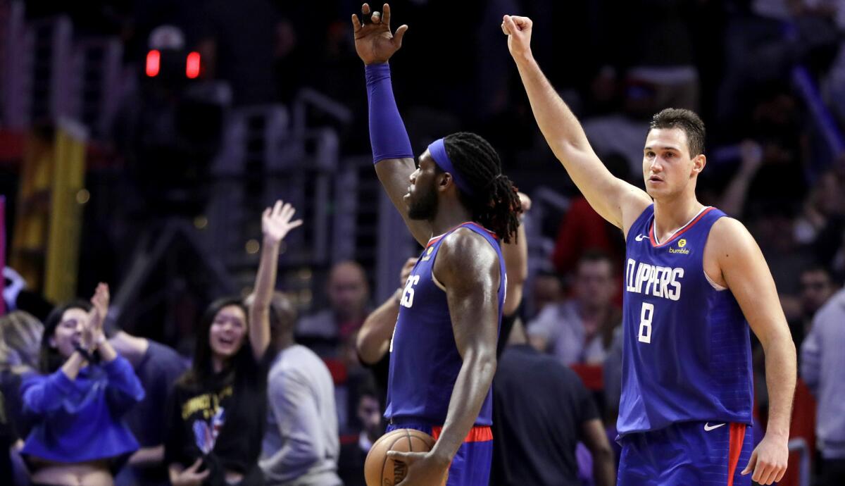 Clippers forwards Montrezl Harrell and Danilo Gallinari (8) celebrate after a 112-107 overtime win against the Memphis Grizzlies on Friday at Staples Center.