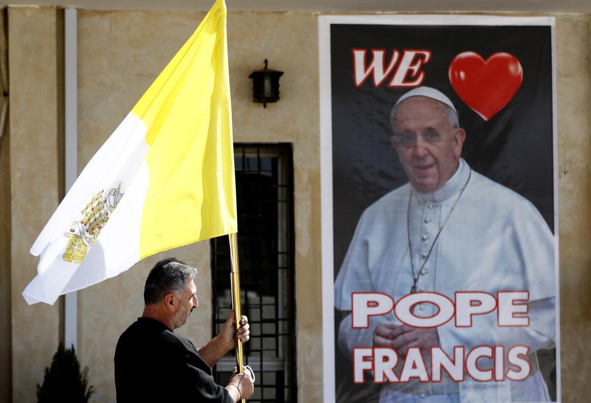 Priest holds Vatican flag in Baghdad