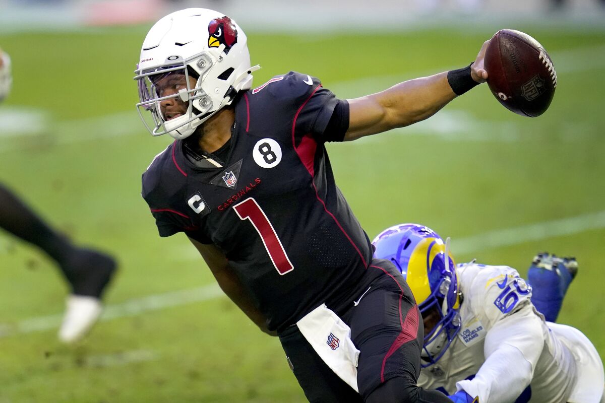 Arizona Cardinals quarterback Kyler Murray (1) eludes the reach of Los Angeles Rams outside linebacker Samson Ebukam (50) during the first half of an NFL football game, Sunday, Dec. 6, 2020, in Glendale, Ariz. (AP Photo/Ross D. Franklin)