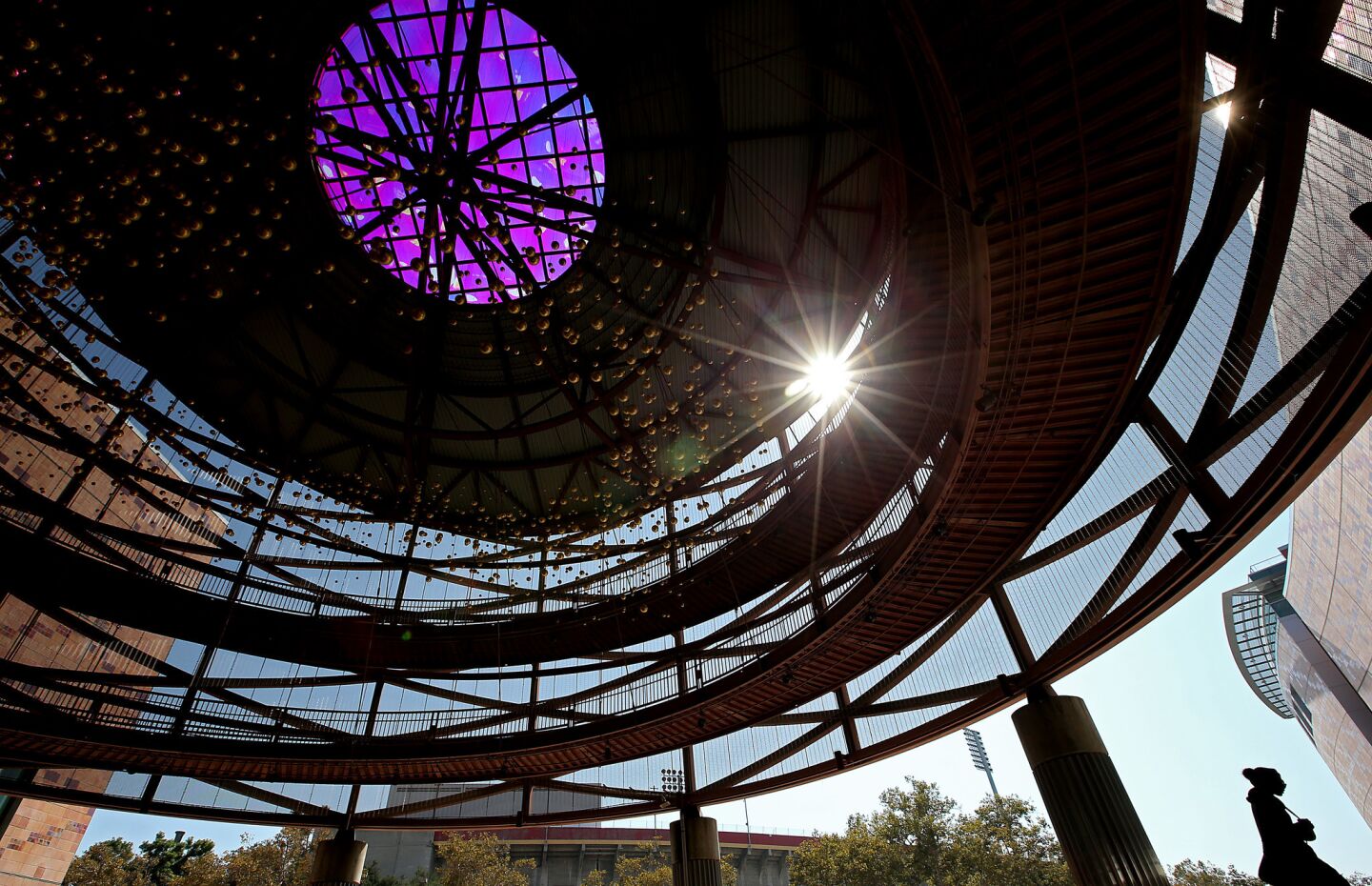 A woman shelters in the shade of the entrance to the California Science Center in Exposition Park.