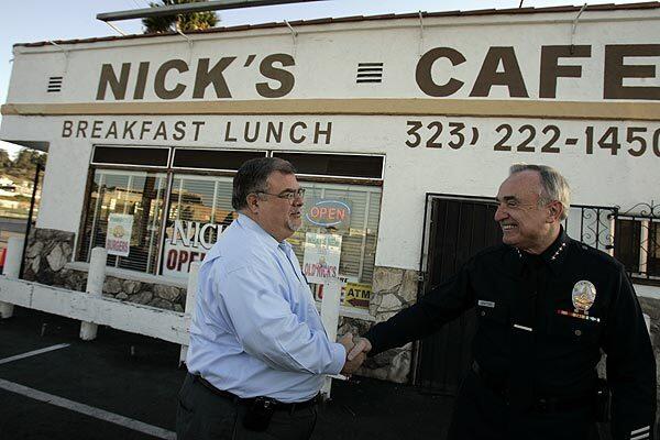 Bratton is greeted by Peter Shutan in front of Nick's Cafe, one of the departing chief's favorite places to have breakfast.