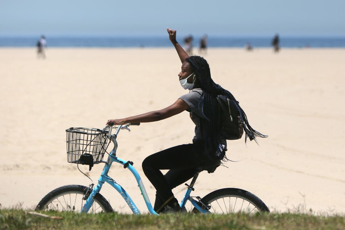 A woman bikes along the Venice Beach Boardwalk on a hot day this summer.