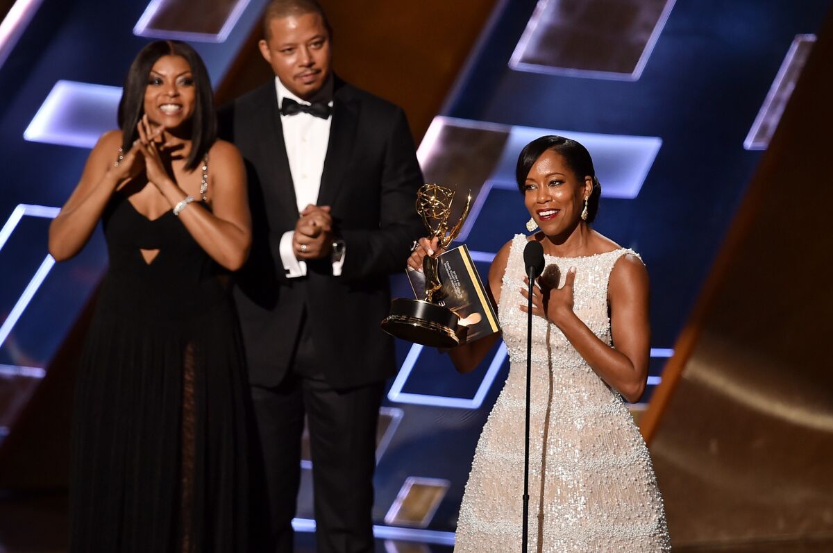 LOS ANGELES, CA - SEPTEMBER 20: Actress Regina King (R) accepts Outstanding Supporting Actress in a Limited Series or Movie award for 'American Crime' from actors Taraji P. Henson (L) and Terrence Howard (C) onstage during the 67th Annual Primetime Emmy Awards at Microsoft Theater on September 20, 2015 in Los Angeles, California. (Photo by Kevin Winter/Getty Images) ** OUTS - ELSENT, FPG - OUTS * NM, PH, VA if sourced by CT, LA or MoD **