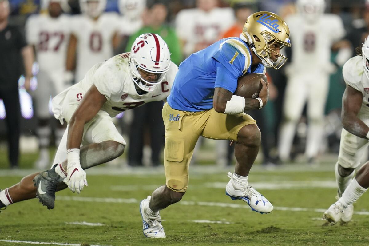 Dorian Thompson-Robinson runs from a leaping Stanford player 