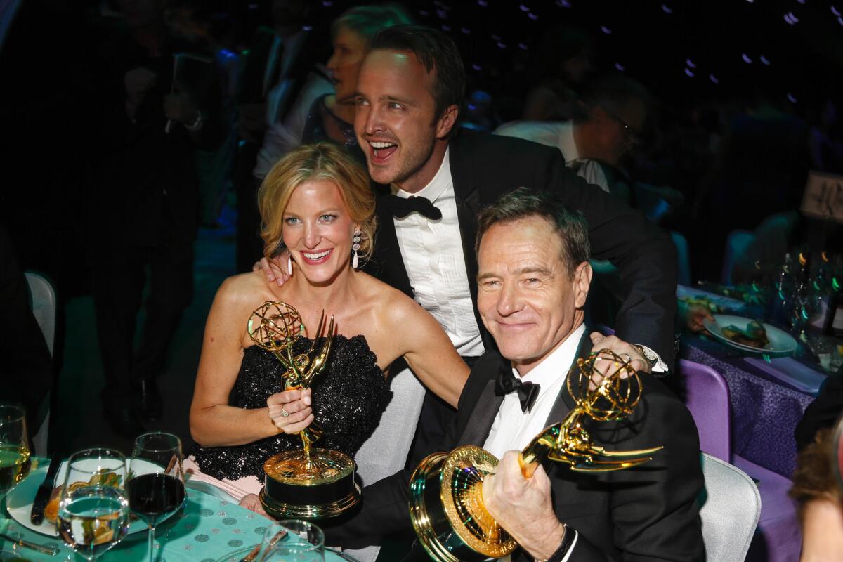At the Governor's Ball, Anna Gunn, Aaron Paul, center, and Bryan Cranston of "Breaking Bad" celebrate Gunn's win for supporting actress in a drama series and the show's win for outstanding drama series.