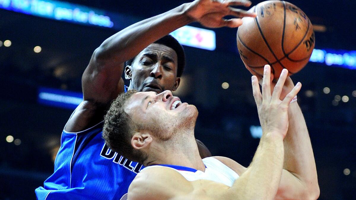 Clippers forward Blake Griffin is fouled by Mavericks forward Jeremy Evans during a play in the first half.