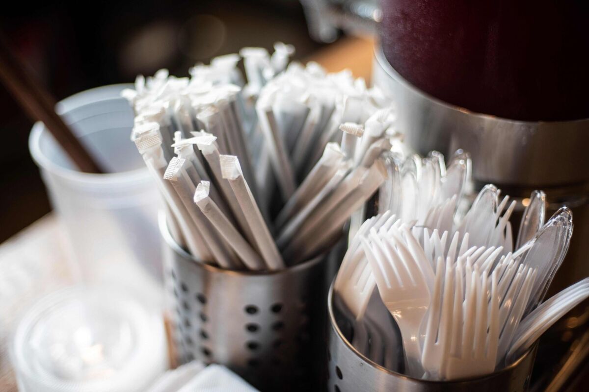 Straws and plastic utensils are set out for customers.