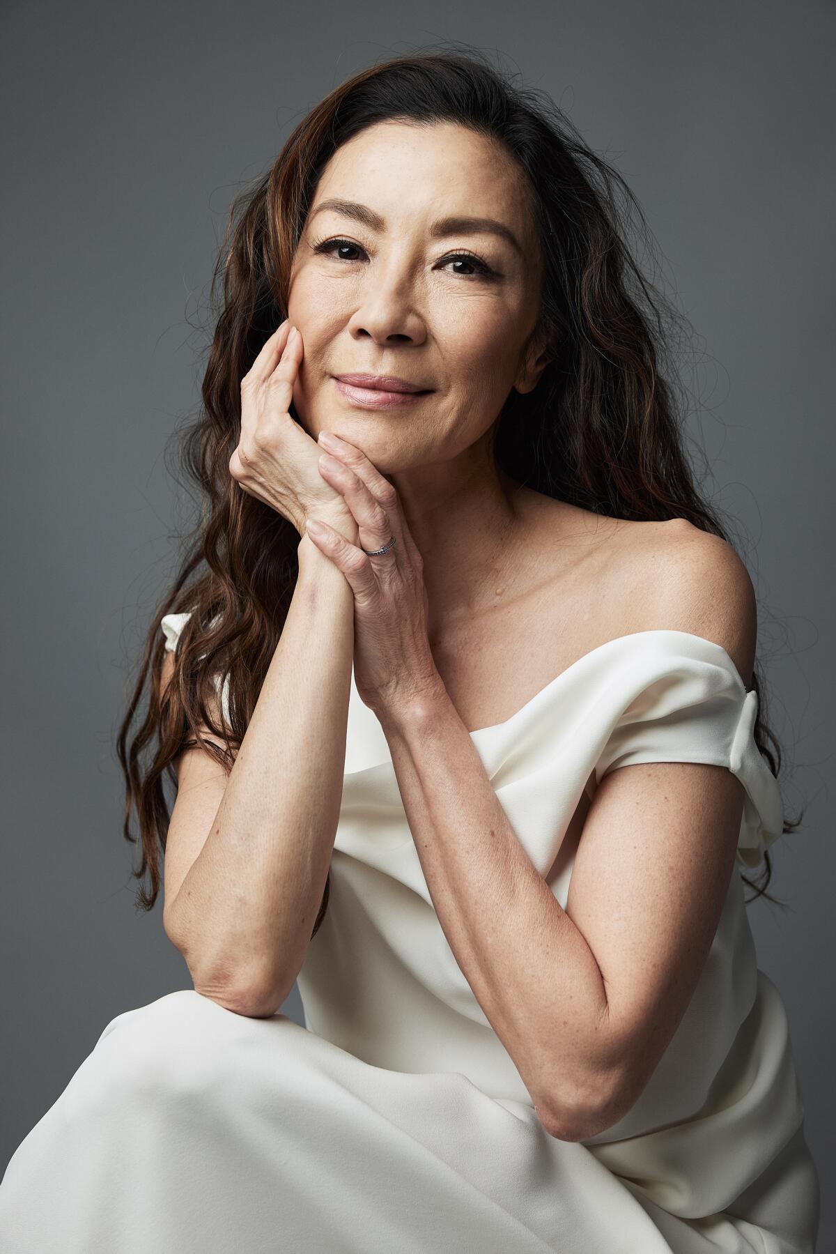 Michelle Yeoh wears a white dress for a portrait.