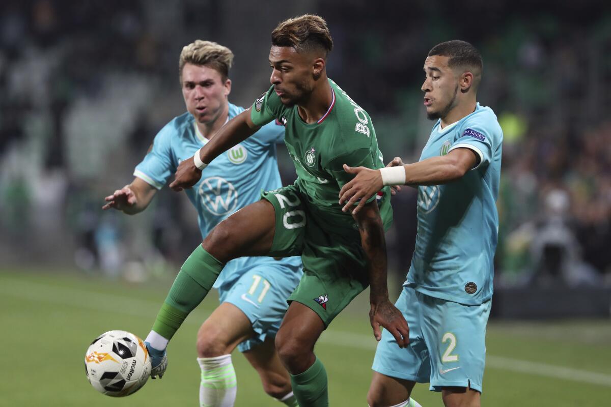 Saint-Etienne's Denis Bouanga, center, challenges for the ball with Wolfsburg's Felix Klaus, left, and William.