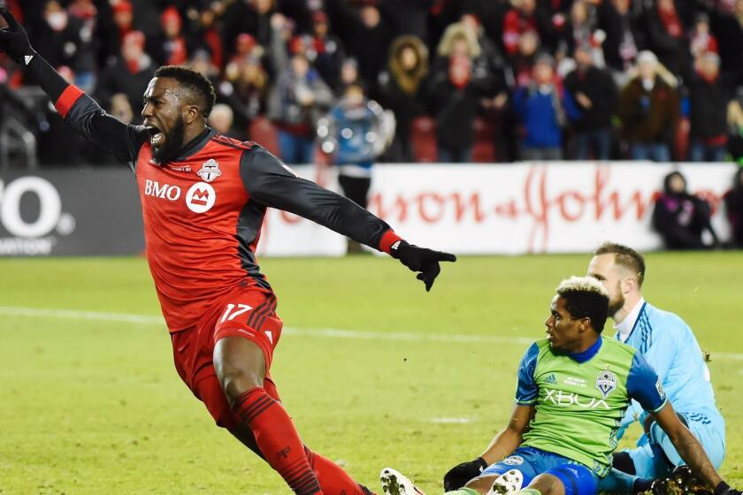 Toronto FC forward Jozy Altidore (17) celebrates after scoring against Seattle Sounders goalkeeper Stefan Frei, right, as defender Joevin Jones looks on during second-half MLS Cup final soccer action in Toronto, Saturday, Dec. 9, 2017. (Nathan Denette/The Canadian Press via AP)