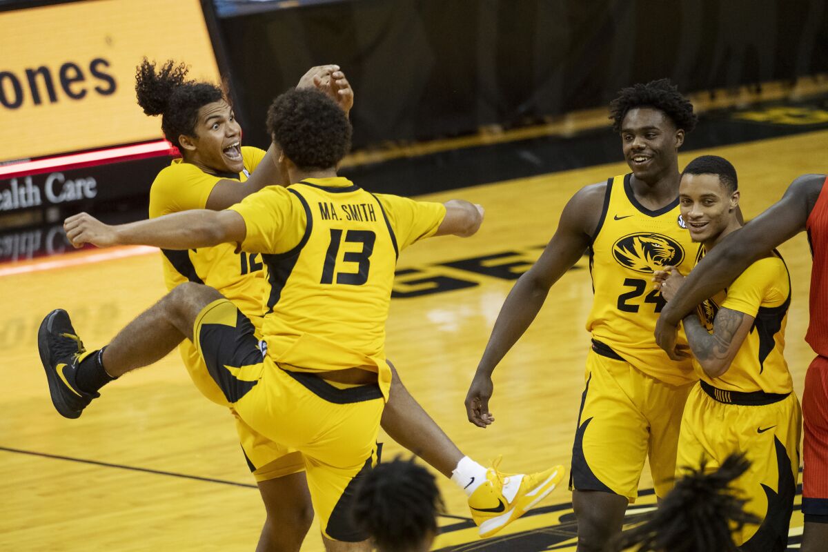 Missouri's Dru Smith, Mark Smith, Kobe Brown and Xavier Pinson, form left, celebrate after Missouri defeated Illinois 81-78 in an NCAA college basketball game Saturday, Dec. 12, 2020, in Columbia, Mo. (AP Photo/L.G. Patterson)