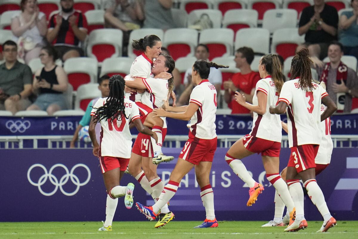 Canada's Vanessa Gilles, third from left, celebrates scoring her side's opening goal 