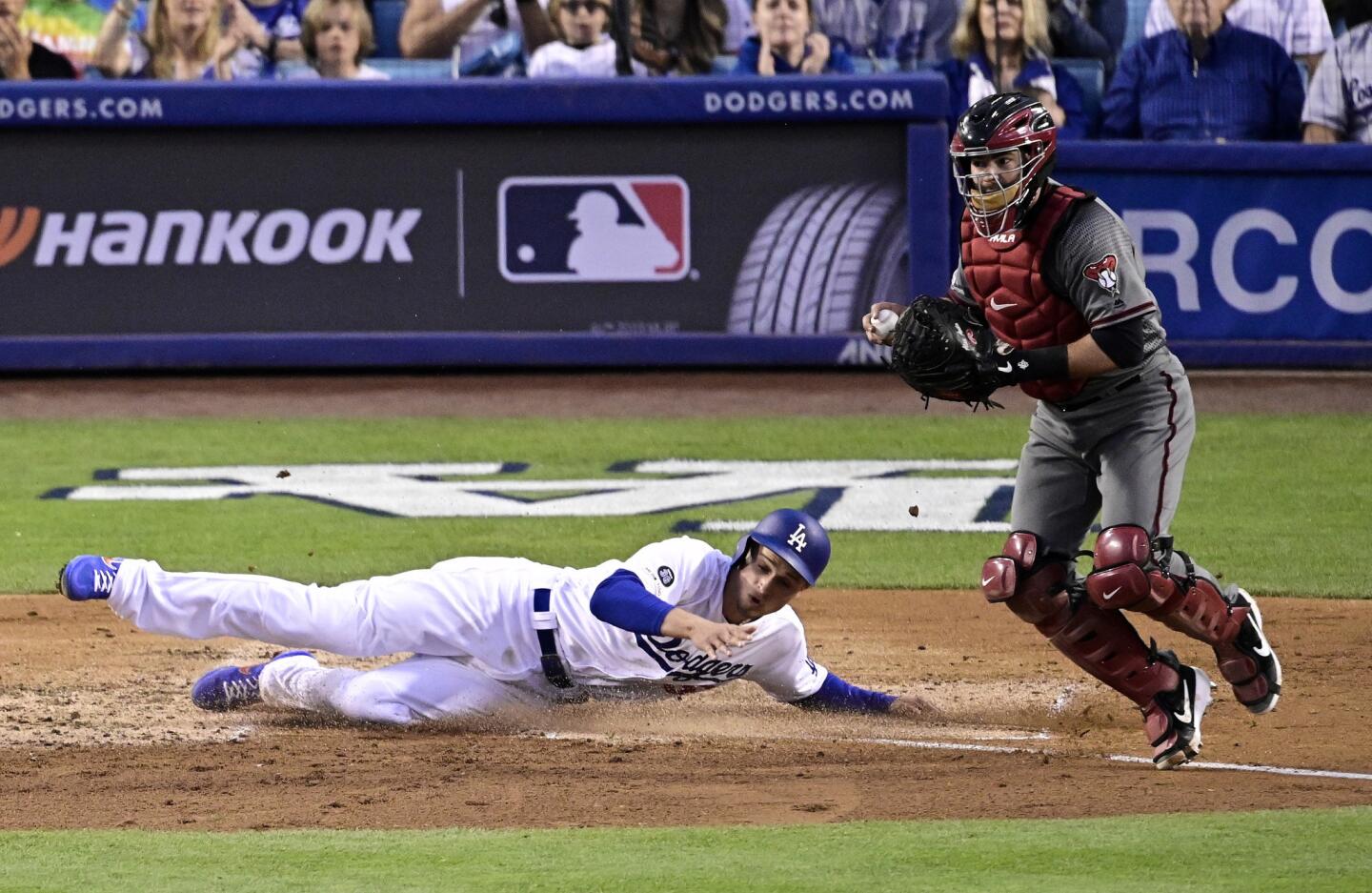 Los Angeles Dodgers' Corey Seager, left, scores on a single by Cody Bellinger as Arizona Diamondbacks catcher Alex Avila takes a late throw during the third inning of a baseball game Saturday, March 30, 2019, in Los Angeles. (AP Photo/Mark J. Terrill)