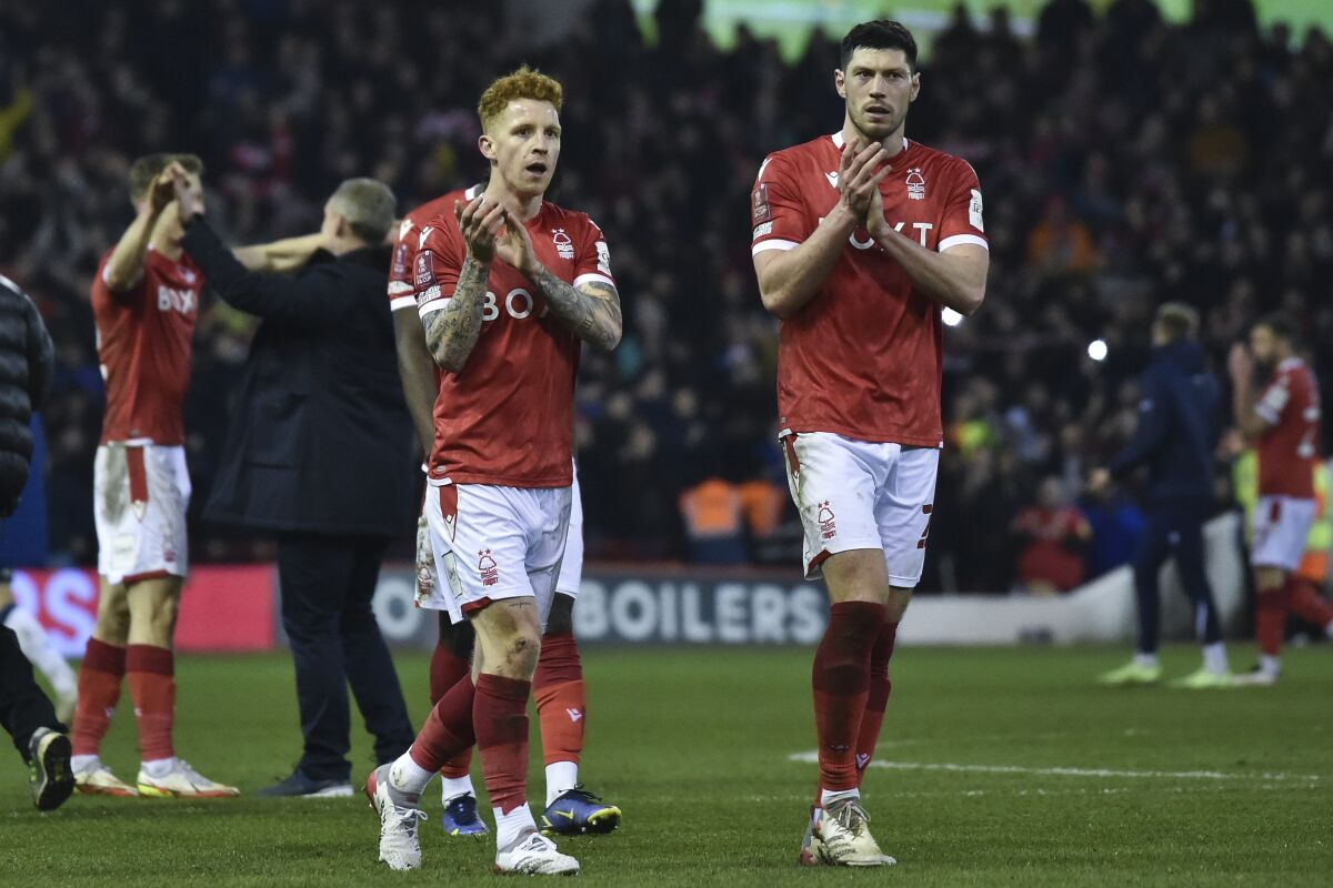Nottingham Forest players celebrate at the end of the English FA Cup fifth round soccer match between Nottingham Forest and Huddersfield Town, at the City Ground, in Nottingham, England, Monday, March 7, 2022. Nottingham won 2-1. (AP Photo/Rui Vieira)