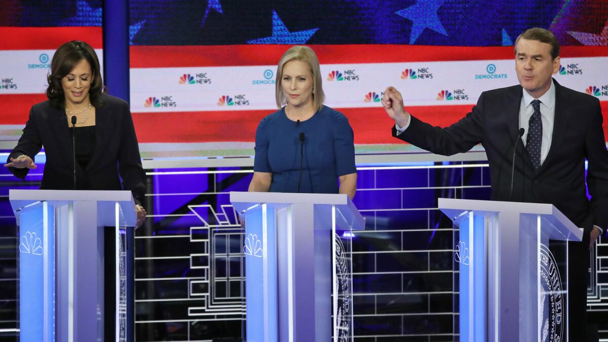 Sen. Michael Bennet speaks while Sens. Kamala Harris, left, and Kirsten Gillibrand listen during the Night 2 of the Democratic presidential debate.