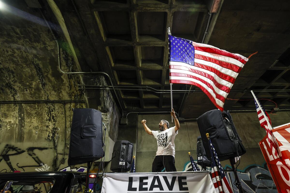 A protester holds a large American flag.