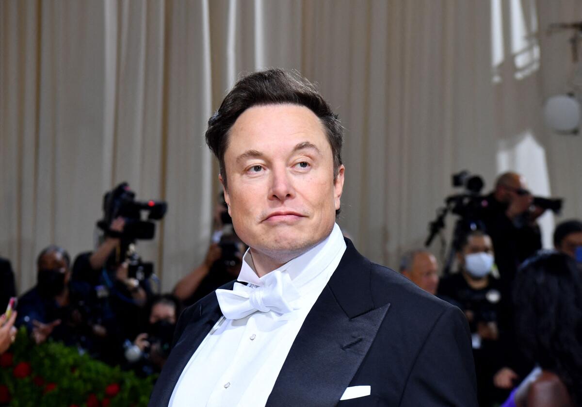 Elon Musk wears a black tuxedo with a white tie. 