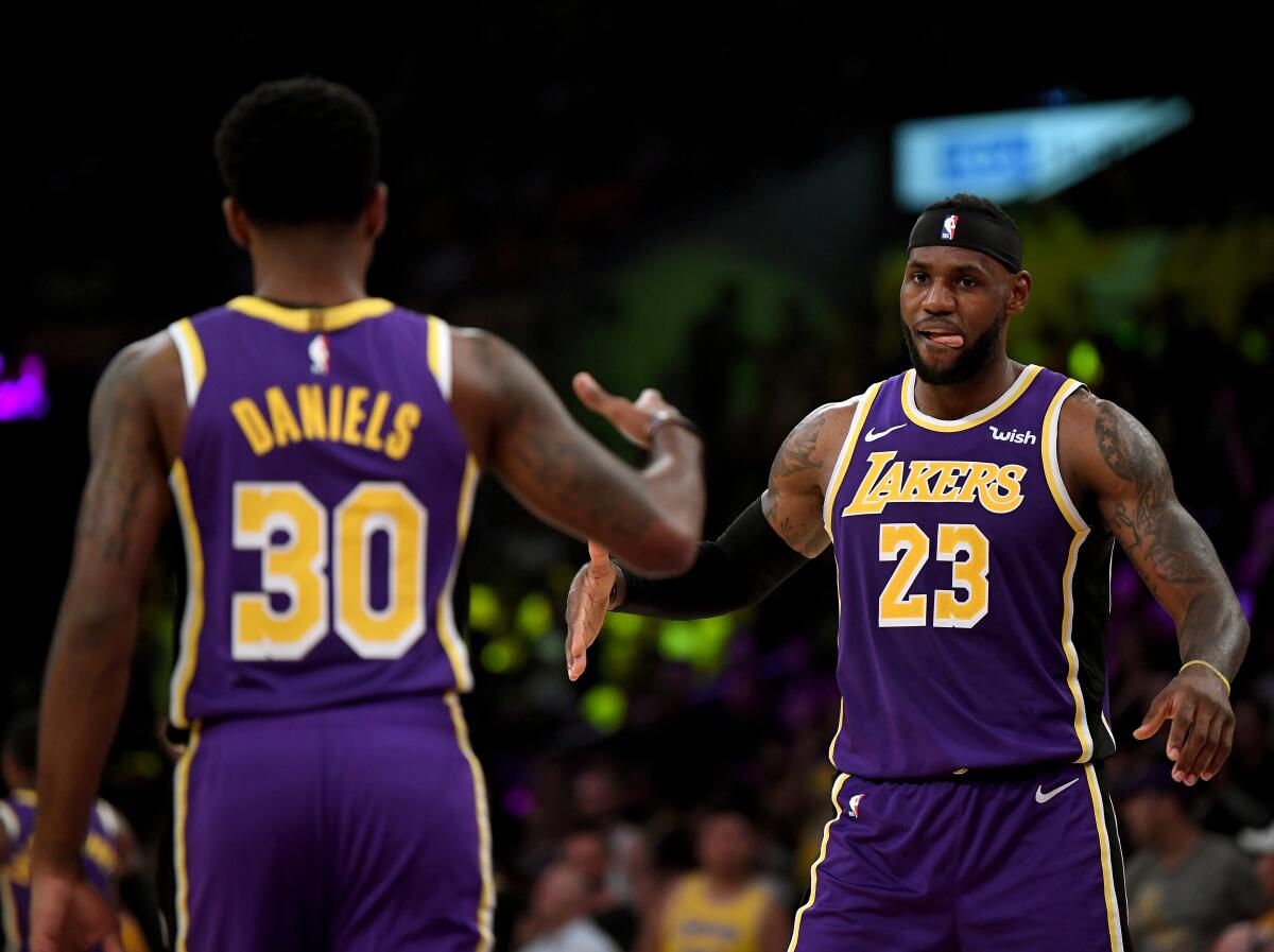 Lakers guard Troy Daniels, left, celebrates with teammate LeBron James after making a three-pointer during a win over the Utah Jazz on Friday.
