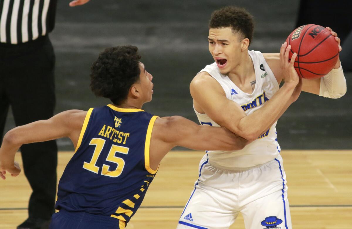 UC Santa Barbara's JaQuori McLaughlin keeps the ball from the reach of UC Irvine's Jeron Artest.