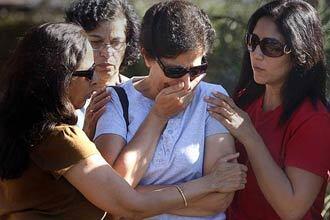 Kusum Arora, center, is surrounded by family and friends after seeing her home in Yorba Linda.