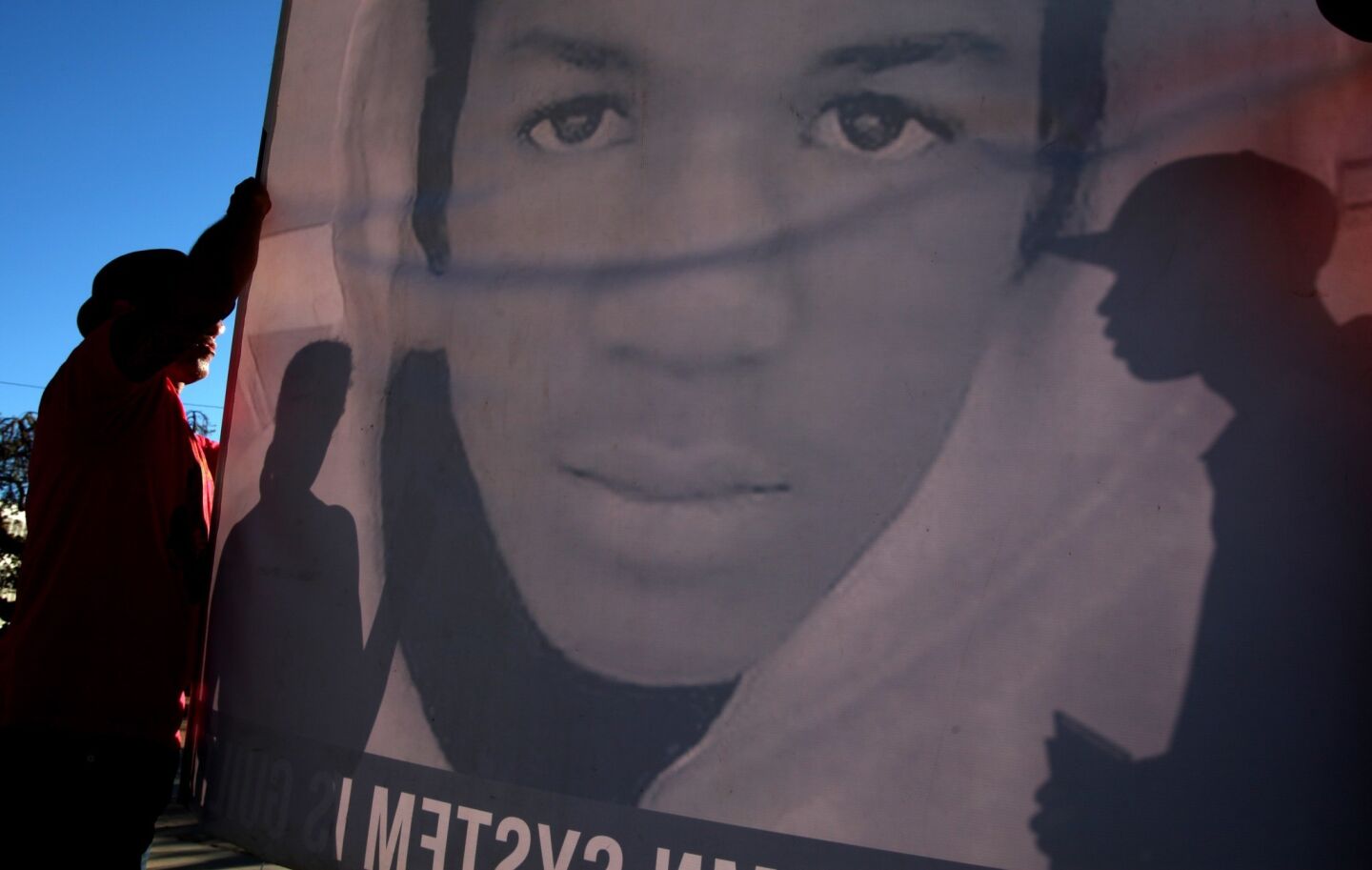 Protesters gathered at Leimert Park on Tuesday afternoon to protest the verdict in the George Zimmerman trial, holding signs and banners with Trayvon Martin's face.