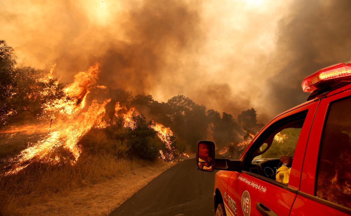 A firefighter maneuvers his vehicle down a private road as the Alamo fire burns near Santa Maria on July 8, 2017. The fire has charred more than 6,000 acres in remote canyons along Highway 166, fed by dry brush and trees in an area that has not burned in many years.