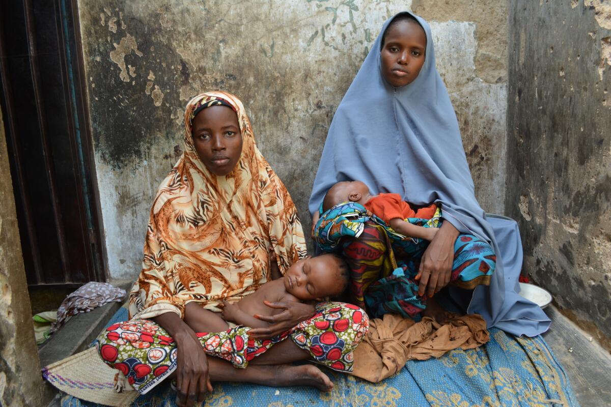 Mohammed Umar's first wife, Mainuna Shuaibu, left, who married the impoverished bricklayer when she was 14, and Maryam Adam, who became his second wife when she was 15, and two of their children at their home in Kano, Nigeria.