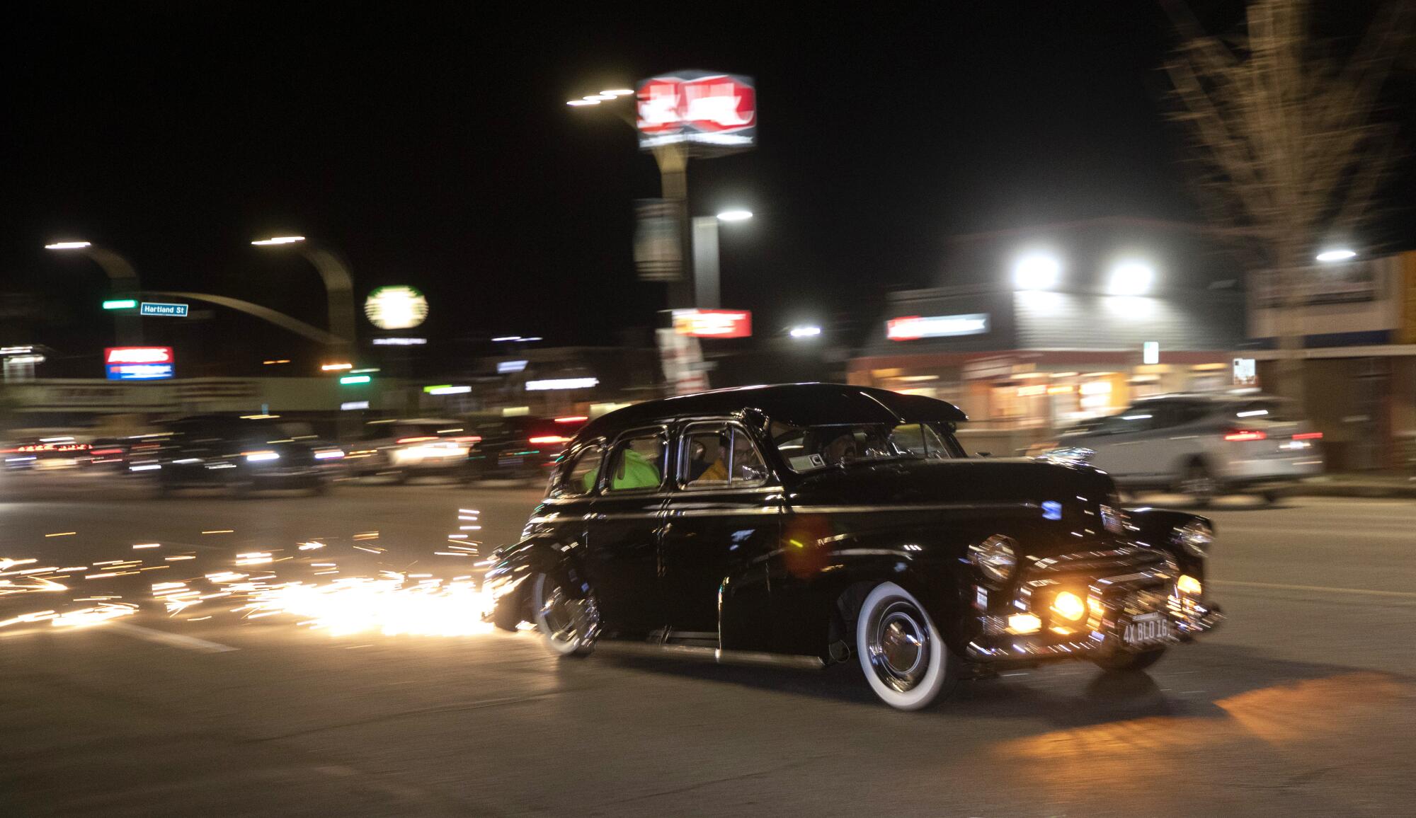 A metal plate attached to the bottom of the car sprays sparks during cruise night on Van Nuys Boulevard. 
