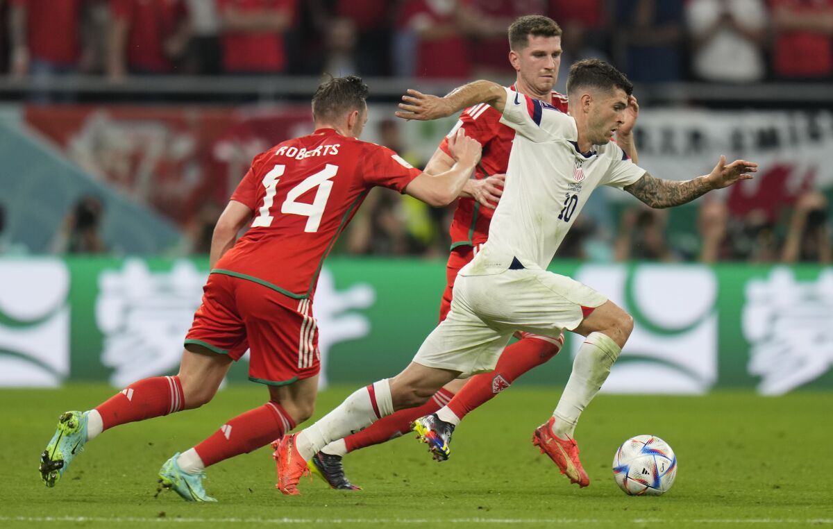 U.S. forward Christian Pulisic, right, controls the ball in front of two Wales players at the World Cup.