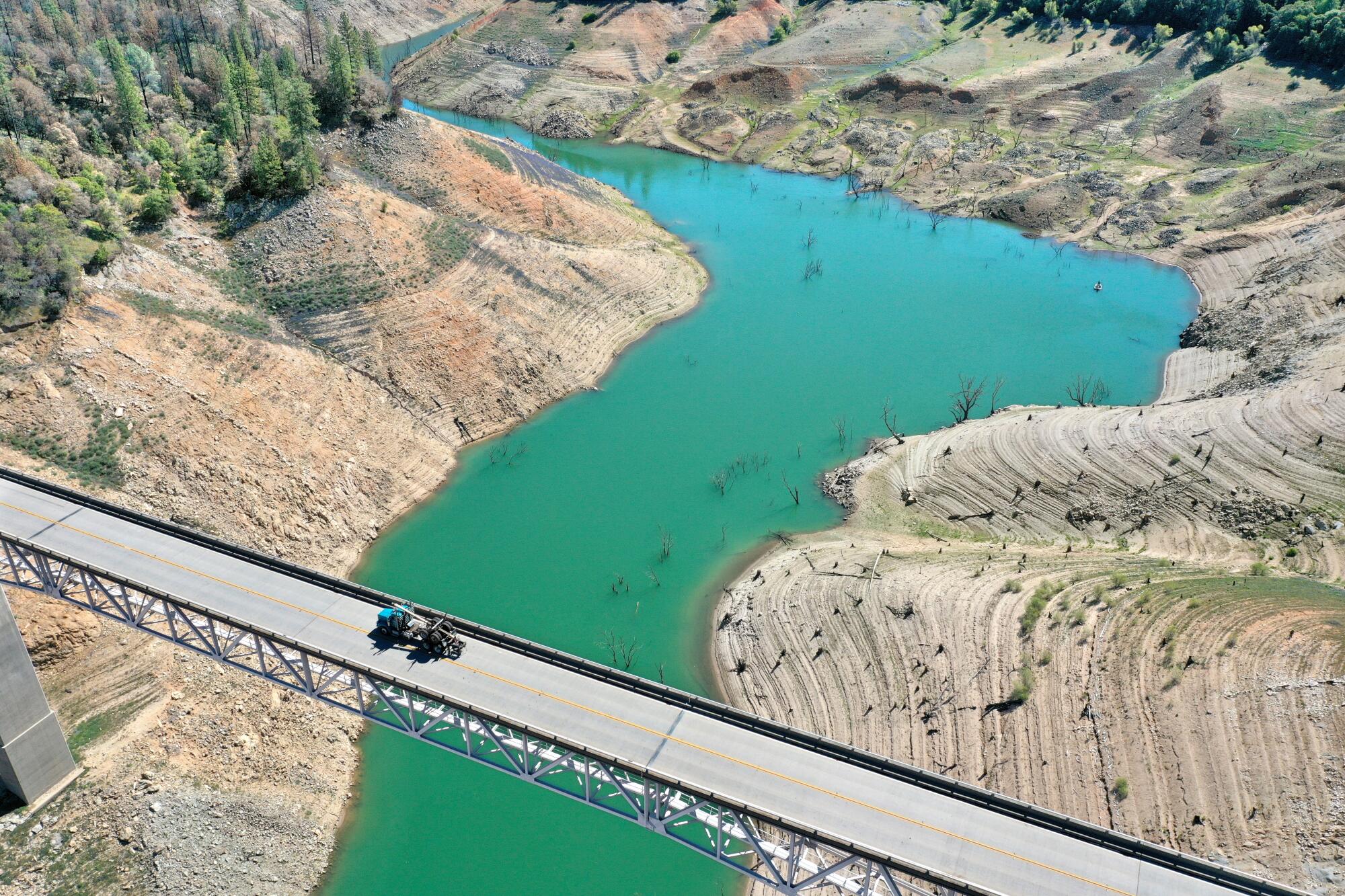 In an aerial view, a truck drives on the Enterprise Bridge over a section of Lake Oroville