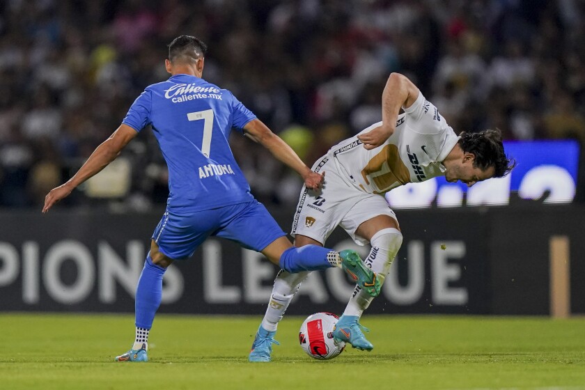 Uriel Antuna of Mexico's Cruz Azul (7) clashes with Alan Mozo of Mexico's Pumas during the first leg semifinal Concacaf Champions League soccer match in Mexico City, Tuesday, April 5, 2022. (AP Photo/Fernando Llano)