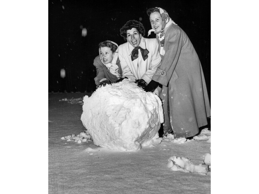 Jan. 11, 1949: Jean Rogers, Mrs. Ted Fio Rito and Mrs. Harvey Holp roll a giant snowball in a front yard in Bel-Air.