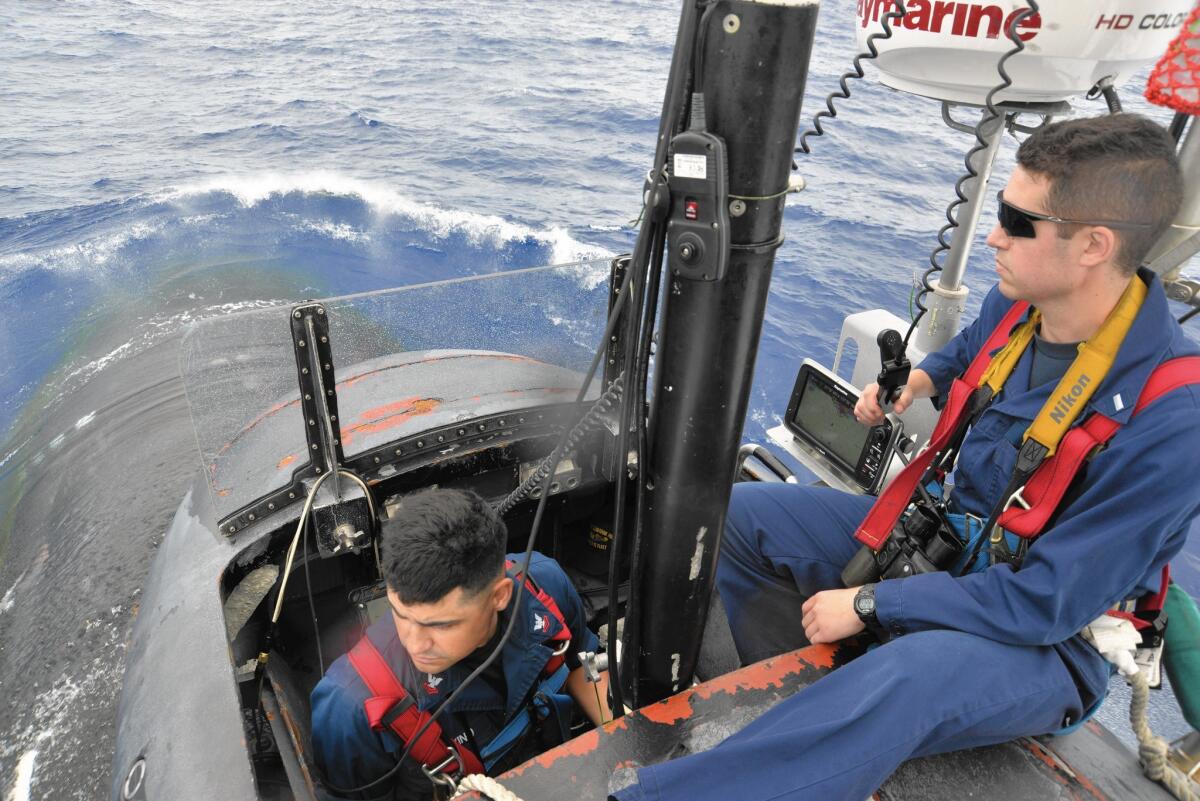 Petty Officer 2nd Class Estevan Trevino, left, and Lt. Rob Graham on the bridge of the Mississippi, a Virginia-class fast-attack submarine, as it departs Pearl Harbor in August before submerging.