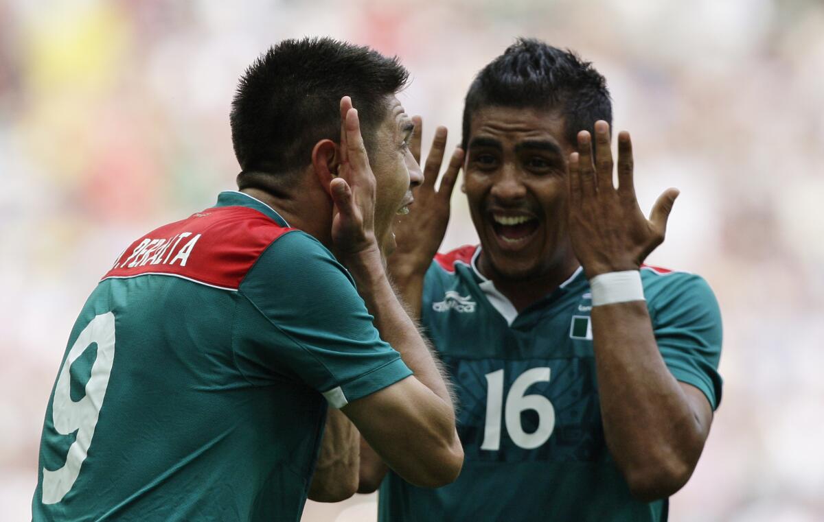 Mexico's Oribe Peralta, left, and teammate Miguel Ponce (16)  