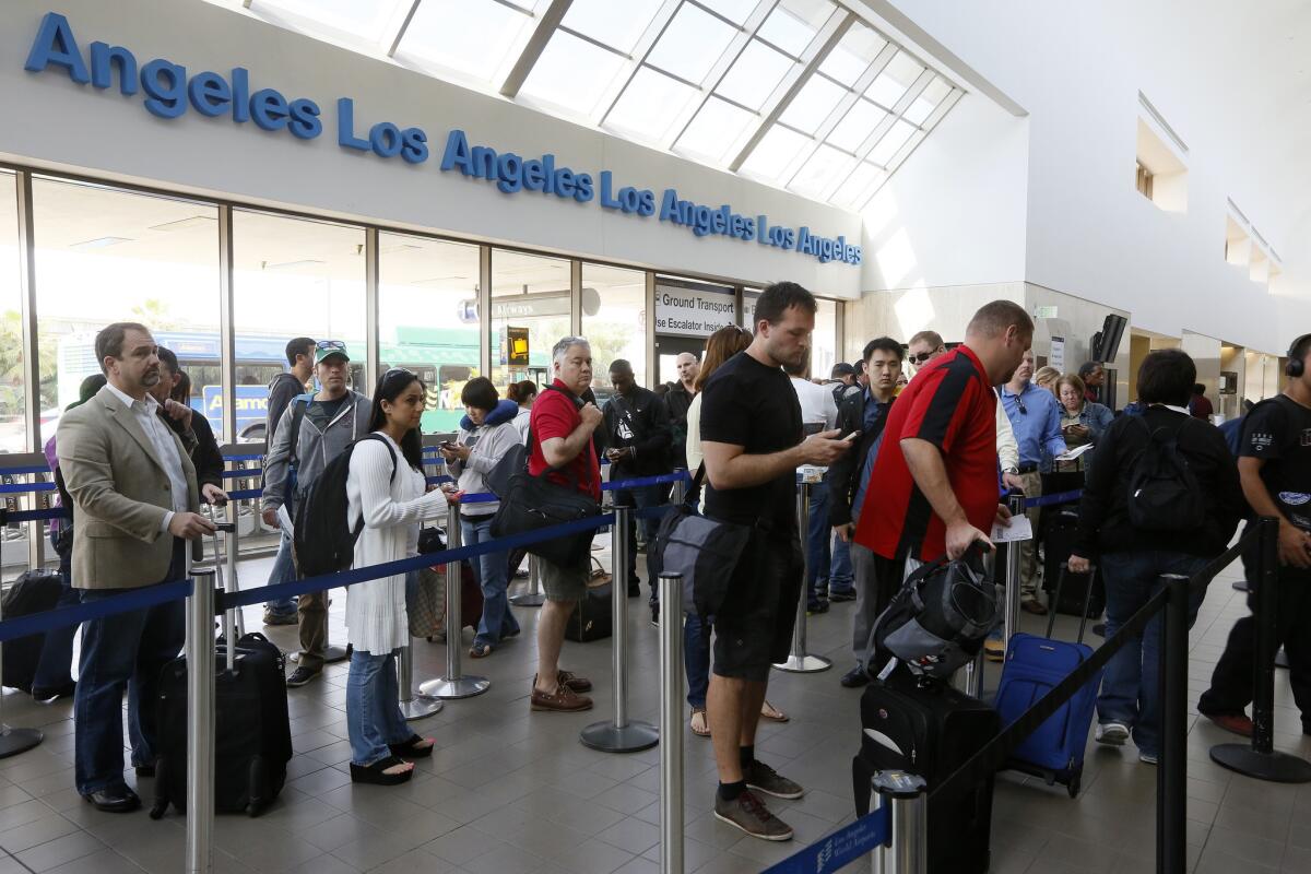 Travelers wait in line at Los Angeles International Airport. The legislation will end furloughs for air-traffic controllers that have caused flight delays at airports nationwide.